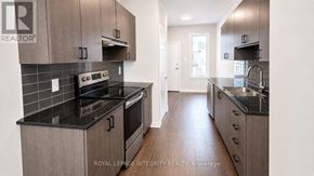 Ottawa townhouse for rent - A modern kitchen with dark countertops and wooden cabinets.