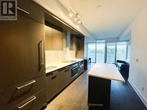 Toronto (Lawrence Park South) condo for rent - A modern kitchen with dark wood cabinets and a white countertop.