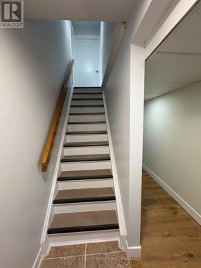 Toronto (Agincourt North) apartment for rent - A staircase with wooden handrail and grey steps.