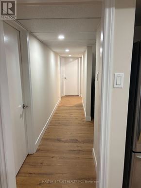 Toronto (Agincourt North) apartment for rent - A long hallway with white doors and wood floors.