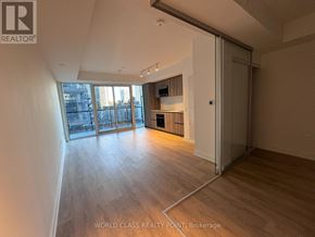 Toronto (Mount Pleasant West) condo for rent - A spacious room with wooden flooring and a sliding glass door leading to a balcony.