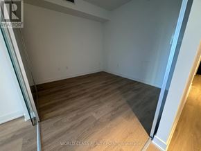 Toronto (Mount Pleasant West) condo for rent - A room with wooden flooring and white walls, with a glass door on the left.