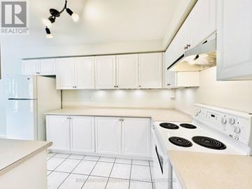 Markham (Berczy) townhouse for rent - A white kitchen with a stove top oven and white cabinets.