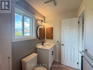 Ottawa townhouse for rent - A bathroom with a toilet, sink, and window.