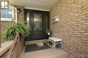 Oakville (Fa Falgarwood) apartment for rent - A black door with a glass window is flanked by a white bench and a brick wall.