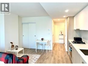Coquitlam apartment for rent - A living room with a couch, a table, and a kitchen area.