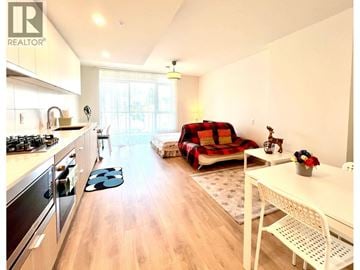 Coquitlam apartment for rent - A well-lit kitchen and living room with a sofa and a dining table.