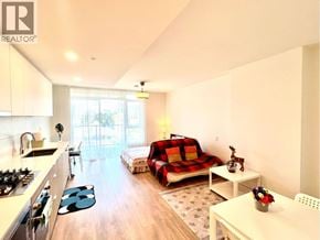 Coquitlam apartment for rent - A well-lit, modern kitchen and living room with a sofa and a dining table.