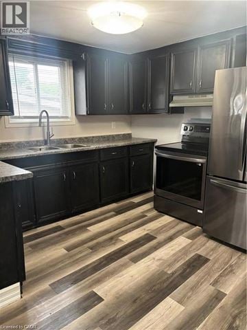 Simcoe apartment for rent - A kitchen with black cabinets and a wooden floor.