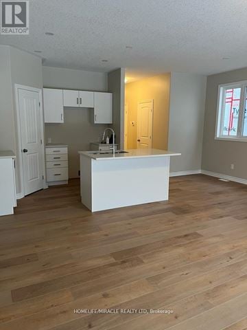 Greater Napanee (Greater Napanee) townhouse for rent - A kitchen with white cabinets and a white island.
