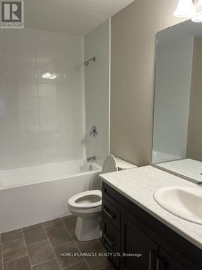 Greater Napanee (Greater Napanee) townhouse for rent - A white toilet sits in a bathroom with a white bathtub and a sink.