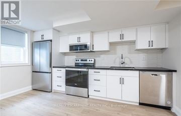Hamilton (Stoney Creek) apartment for rent - A kitchen with white cabinets and stainless steel appliances.