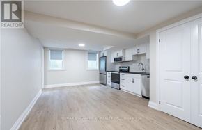 Hamilton (Stoney Creek) apartment for rent - A well-lit, spacious kitchen with white cabinets and a microwave above the stove.