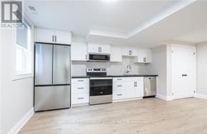 Hamilton (Stoney Creek) apartment for rent - A white kitchen with a refrigerator, oven, microwave, and cabinets.