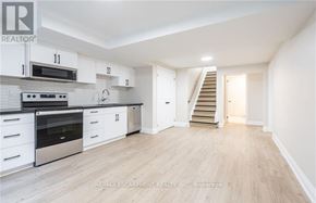 Hamilton (Stoney Creek) apartment for rent - A spacious kitchen with white cabinets and a stainless steel oven.