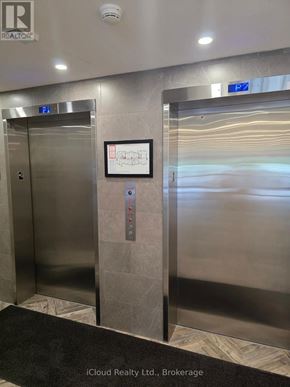 London North (North R) condo for rent - Two stainless steel elevators in a hallway with a sign on the wall.