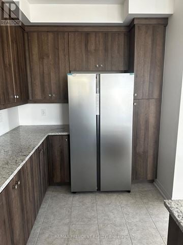 Brampton (Sandringham-Wellington North) townhouse for rent - A kitchen with a refrigerator and cabinets.