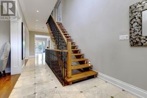 Toronto (Islington-City Centre West) apartment for rent - A hallway with a wooden staircase and a marble framed mirror on the wall.