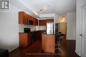 Mississauga (City Centre) condo for rent - A kitchen with wooden cabinets and a black counter top.