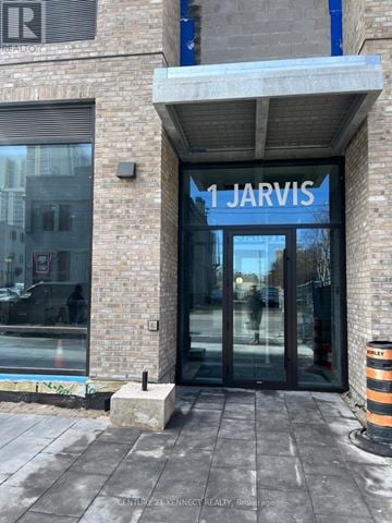 Hamilton (Beasley) condo for rent - The entrance to a building with a glass door and a sign that reads "1 Jarvis".