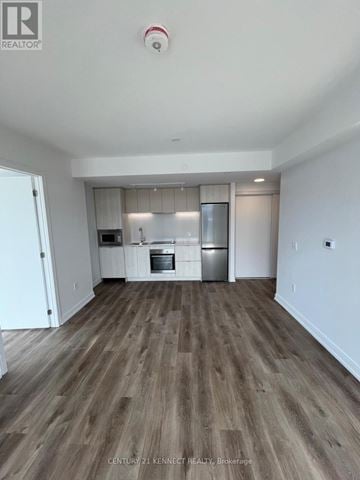 Hamilton (Beasley) condo for rent - A spacious kitchen with white cabinets and a wooden floor.