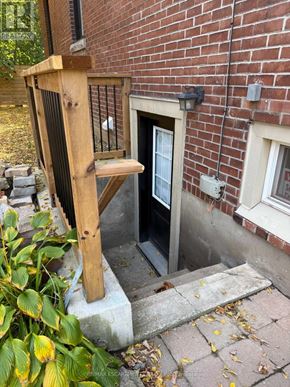 Hamilton (Mountview) apartment for rent - A wooden chair is leaning against a brick wall next to a door.