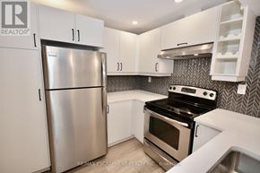 Hamilton (Mountview) apartment for rent - A kitchen with a stainless steel refrigerator and a black stove top oven.