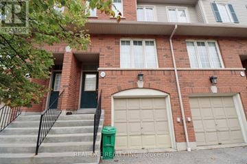 Mississauga (Hurontario) townhouse for rent - A red brick building with a green door and a white window.