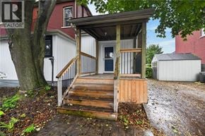 Hamilton apartment for rent - A small wooden structure with a porch and steps leading up to a door.