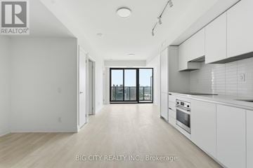 Toronto (Thorncliffe Park) condo for rent - A spacious kitchen with white cabinets and a large window.