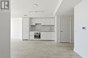 Toronto (Thorncliffe Park) condo for rent - A white kitchen with a refrigerator, oven, and cabinets.