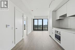 Toronto (Thorncliffe Park) condo for rent - A spacious kitchen with white cabinets and a view of the city.