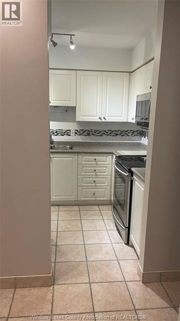 Windsor condo for rent - A kitchen with white cabinets and a tile floor.