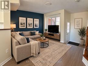 Ottawa townhouse for rent - A living room with a couch, a coffee table, and a flat screen TV.