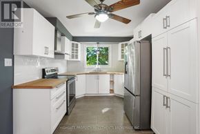 Barrie (Cundles East) apartment for rent - A kitchen with white cabinets and a wooden countertop.