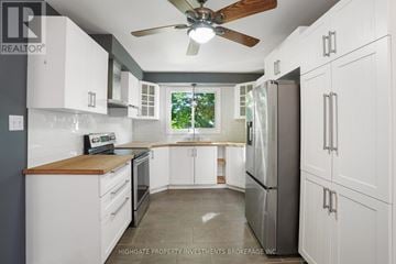 Barrie (Cundles East) apartment for rent - A kitchen with white cabinets and a wooden countertop.