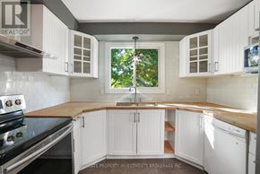 Barrie (Cundles East) apartment for rent - A kitchen with white cabinets and a black stove top oven.