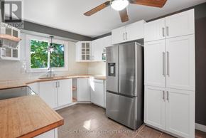 Barrie (Cundles East) apartment for rent - A kitchen with white cabinets and a stainless steel refrigerator.