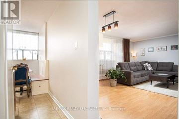 Burlington (Roseland) condo for rent - A living room with a grey couch and a wooden floor.