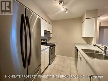 Toronto (Waterfront Communities) condo for rent - A kitchen with a stainless steel refrigerator and white cabinets.