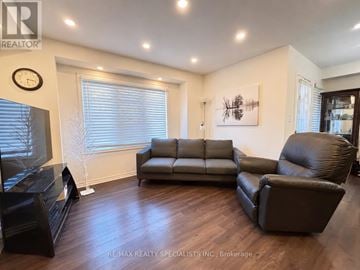 Milton (Fo Ford) townhouse for rent - A living room with a grey couch, a black leather chair and a black entertainment center.