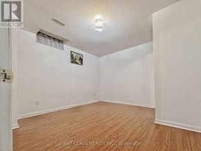 Markham (Milliken Mills East) apartment for rent - A room with wooden flooring and white walls, with a picture hanging on the wall.
