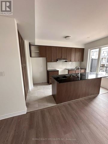 Brampton (Northwest Brampton) townhouse for rent - A modern kitchen with wooden cabinets and a black countertop.