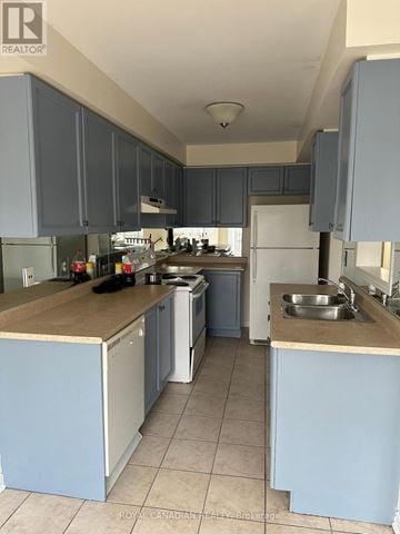 Mississauga (Meadowvale Village) townhouse for rent - A kitchen with blue cabinets and a white refrigerator.