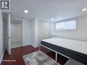 Burnaby apartment for rent - A bedroom with a bed, a rug, and a window.