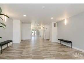 Langley apartment for rent - A long hallway with benches on either side and a plant in the corner.