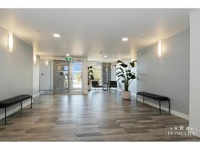 Langley apartment for rent - A spacious hallway with wooden floors and benches on either side.