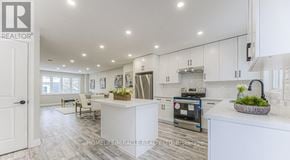Kitchener apartment for rent - A modern kitchen with white cabinets and a central island.