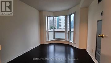 Toronto (Waterfront Communities) condo for rent - A room with a large window and a view of a building outside.
