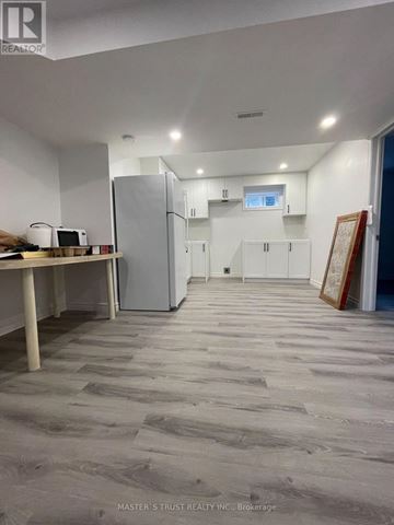 Toronto (Agincourt North) apartment for rent - A kitchen area with a refrigerator, microwave, and cabinets.